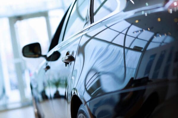 Close-up of the 99 Special, a sleek and reflective black car, with a blurred indoor background.